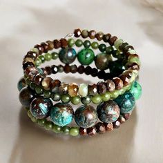 Shades of green, blue, and brown dominate this beaded coil wrap bracelet. Faceted chrysoprase, round jade, and African turquoise come together in a medley of tone and texture in this done-for-you stack. I love the earth tones and contrast of size, color, and texture in this one-of-a-kind bracelet. 4mm round jade 4x5mm faceted chrysoprase 10mm African turqouise one size fits most - best for small to medium wrists Handmade in Lincoln, Nebraska Bohemian Jade Jewelry Hand Wrapped, Bohemian Hand Wrapped Jade Jewelry, Bohemian Hand-wrapped Jade Jewelry, Bohemian Turquoise Gemstone Beads Wrap Bracelet, Bohemian Turquoise Wrap Bracelet With Gemstone Beads, Artisan Turquoise Hand Wrapped Wrap Bracelet, Artisan Hand Wrapped Turquoise Wrap Bracelet, Bohemian Jade Bracelets, Artisan Hand Wrapped Wrap Bracelet With Round Beads