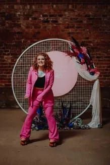 a woman standing in front of a round object