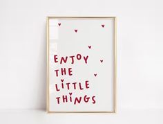 an art print with the words enjoy the little things written in red ink on a white background