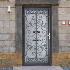 an iron door on the side of a stone building with two lights above it and below it