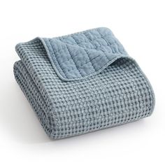 a blue blanket folded on top of a white surface with a black and white checkered design