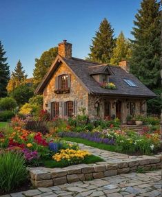 a stone house surrounded by colorful flowers and greenery in the foreground is a path leading to it