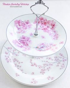 two plates are stacked on top of each other with pink flowers painted on the plates