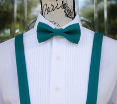 a white shirt with green suspenders and a bow tie