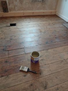 a paint can with a brush on the floor