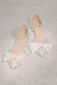 a pair of white shoes with bows on them