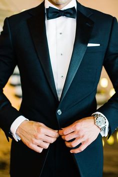 a man in a tuxedo is wearing a watch