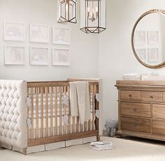 a baby crib in a room with pictures on the wall