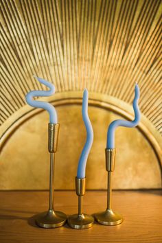 two blue candlesticks sitting on top of a wooden table