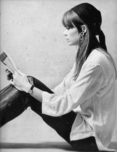 a woman sitting on the floor reading a book