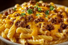 a close up of a plate of macaroni and cheese with meat on it