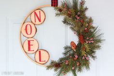 an image of a christmas wreath on the front door with pine cones and ornaments around it