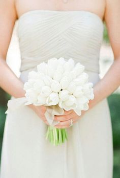 a bride holding a bouquet of white flowers