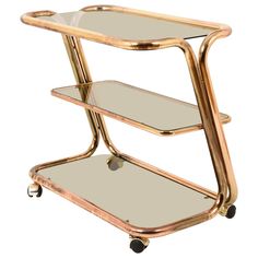 a gold metal and glass serving cart with wheels