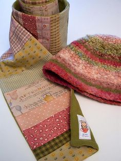 there are many different pieces of fabric on the table together, including a hat and scarf