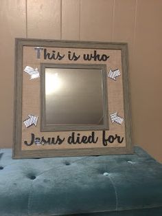 this is who jesus died for framed mirror on blue velvet bench in room with wood paneling