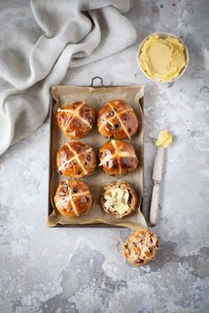 hot cross buns with butter on a baking tray