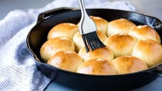 a skillet filled with bread rolls and a fork sticking out of the top one