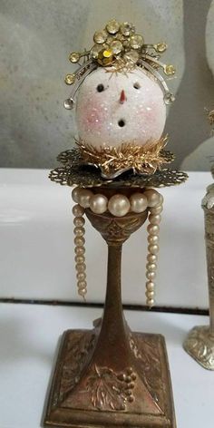 an ornate figurine with pearls and beads on it's head is displayed