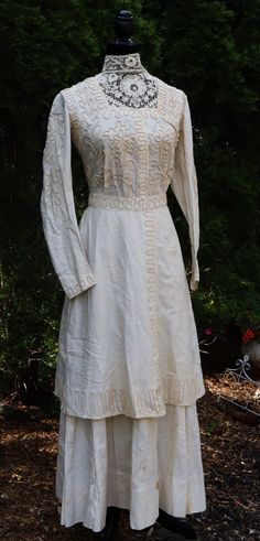 Antique Edwardian Victorian linen with raised braided ornate scrollwork and lace collar dress color ivory, In overall good antique condition for its age, No damage, Some satins on it, Sold as it, The pictures is part description, Weighs 1.1 pound. Thanks. Full Length: 54"  Shoulder : 14"1/2 Bust: 28" Waist: 24" Collar about 20"1/2 Sleeves  22" long  Ship Us only Victorian Cream Dress For Daywear, Vintage Cream Dress With Lace Collar, Elegant Wedding Dress With Yoke Detail, Elegant Wedding Dress With Yoke, Victorian Cream Vintage Dress With Lace Trim, Cream Victorian Vintage Dress With Lace Trim, White Vintage Dress With Historical Design, Vintage Linen Wedding Dress, Elegant Dresses With Historical Design For Daywear