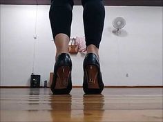 a woman's legs in high heels standing on the floor