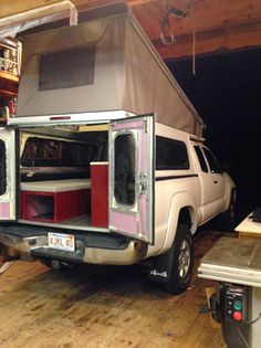 the truck is parked in the garage with it's doors open