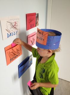 a young boy wearing a paper crown on top of his head next to post it notes