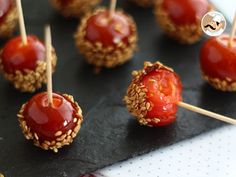 some food that is sitting on a black plate and has toothpicks in it