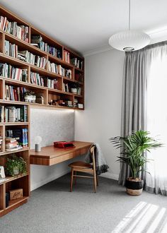 a wooden desk sitting in front of a book shelf filled with books