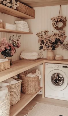 a washer and dryer in a small room with baskets on the shelves next to it