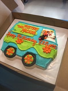 a birthday cake in the shape of a school bus with orange flowers on it's side