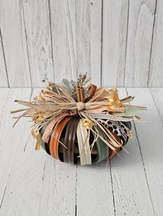 a small decorative pumpkin sitting on top of a white table next to a wooden wall