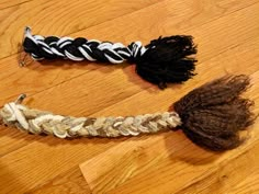 two pieces of rope on the floor with some tassels attached to one end