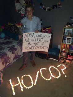 a young man holding a sign that says horosh in front of him on the floor