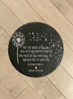 a black stone with a dandelion on it and a poem written in white