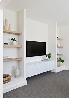 a living room with shelves and a flat screen tv