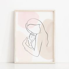 a black and white drawing of a woman holding a baby in her arms on a wall