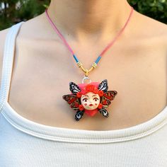 "Handmade Red Clay Face Necklace with Butterfly Wings, Artisan Pendant, Boho Jewelry, Unique Gift, Witchy Necklace, Festival Accessory, Halloween Jewelry, Christmas Gift, Fairycore, Y2K Jewelry" Elevate your style with this one-of-a-kind red clay face necklace, designed with intricate butterfly wings that bring an ethereal and whimsical touch. This handcrafted artisan pendant is perfect for lovers of boho, witchy, fairycore, and Y2K-inspired jewelry. Make a statement and express your unique personality with a piece that's truly distinctive. This necklace is ideal for a variety of occasions, from music festivals and Halloween parties to casual wear and holiday gatherings. Whether you're into alternative fashion, fantasy vibes, or gothic aesthetics, this statement necklace is sure to catch e Handmade Red Artsy Necklaces, Bohemian Adjustable Necklace With Mushroom Design, Butterfly Clay Necklace, Moth Necklace, Unique Red Polymer Clay Necklace, Y2k Jewelry, Face Necklace, Whimsical Jewelry, Clay Faces