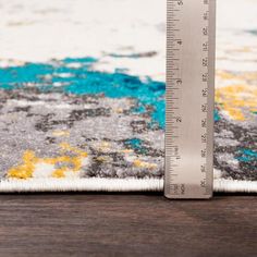 a measuring tape is on top of a rug with an area rug in the background