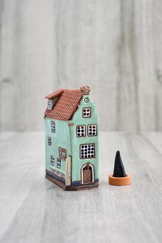 a small toy house next to a black marker