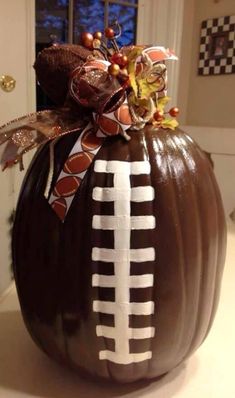 a chocolate pumpkin decorated to look like a football on the side with ribbon and bow