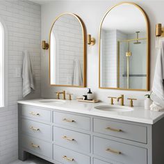 a bathroom with two sinks and three mirrors