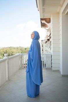 Introducing the Calinia Prayer Gown Two-Piece Set in Blue Color Khimar, designed by the renowned brand Annah Hariri. This exquisite ensemble is crafted with meticulous attention to detail, ensuring a blend of comfort, style, and modesty for your prayer rituals and sacred journeys, such as Umrah.The star of this set is the stunning blue-colored khimar, exuding a sense of elegance and timeless beauty. Its rich blue hue complements a range of skin tones, adding a touch of sophistication to your pra Modest Blue Niqab For Eid, Traditional Blue Hijab For Eid, Blue Modest Khimar For Eid, Blue Long Sleeve Modest Khimar, Annah Hariri, Modest Activewear, Full Coverage Swimsuit, Abaya Dress, Comfort Style