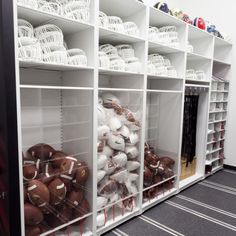 footballs and other sports equipment are on display in the locker room at an athletic facility