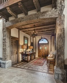 the entry way to a large home with stone and wood trimmings on the walls