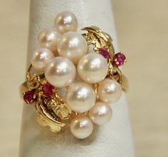 "This prominent vintage cocktail ring is accented with Ten (10) post set natural salt water pearls (Japanese Pearls). The pearls are bordered with four (4) prong set, round facet cut rubies.  The ring measures about 1\" tall from bottom of band and rises abt 1/2\" above the finger.  The ring is currently a size 7 1/2. Wonderful addition to any jewelry wardrobe.  Perfect for any special life event such as graduation, milestone birthdays, Promise Ring or wedding Gift etc.  A much cherished and tre Luxury Multi-stone Pearl Ring Fine Jewelry, Luxury Pearl Ring With Gemstone, Cluster Pearl Ring, Luxury Pearl Gemstone Ring For Anniversary, Japanese Pearls, Pearl Rings, Jewelry Wardrobe, Vintage Cocktail Ring, Rings Jewelry Fashion