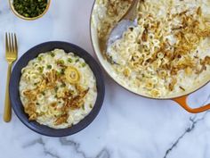 two pans filled with macaroni and cheese on top of a marble counter