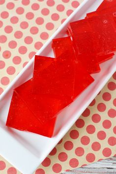 a white plate topped with red jelly on top of a table