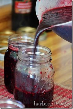 red liquid being poured into jars on a table