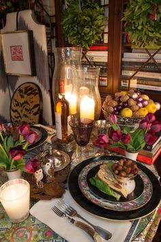 the table is set with plates, silverware and candles